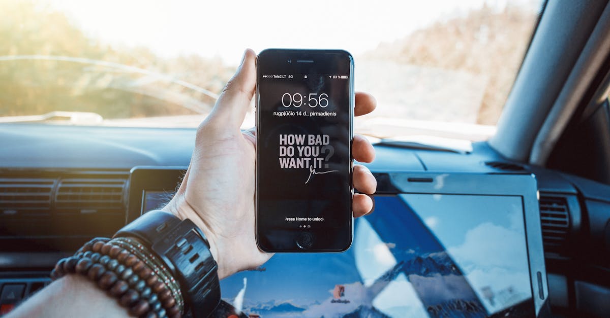 Close-up of a hand holding a smartphone in a car, highlighting technology and motivation.